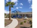 Community playground featuring a shade structure, slides, and climbing elements in a landscaped setting at 1859 S 181St Dr, Goodyear, AZ 85338