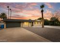 Charming home boasts desert landscaping, complemented by palm trees and a newly sealed driveway at 1911 E Lawrence Rd, Phoenix, AZ 85016