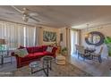 Bright living room featuring a comfortable red sofa, neutral tones, stylish decor, and an inviting atmosphere at 19777 N 76Th St # 2142, Scottsdale, AZ 85255