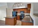 Modern kitchen featuring an island, dark wood cabinetry, and black appliances at 280 S Evergreen Rd # 1296, Tempe, AZ 85288