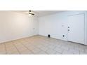 Bright, tiled living space with neutral walls, fan, and two access doors at 3115 N 55Th Ave, Phoenix, AZ 85031