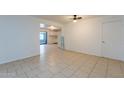 Spacious living room featuring neutral tile flooring, ceiling fan, and view to kitchen at 3115 N 55Th Ave, Phoenix, AZ 85031