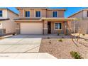 Home exterior featuring desert landscaping, two-car garage, neutral color palette, and a well-maintained front yard at 31850 N Bandit Rd, San Tan Valley, AZ 85143
