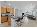 Open kitchen with granite countertops, stainless steel appliances, and breakfast bar seating at 3597 E Henson St, San Tan Valley, AZ 85140