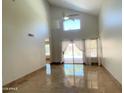 Bright living room featuring vaulted ceilings, neutral walls, tile floors, and sliding doors to the backyard at 4034 E Anderson Dr, Phoenix, AZ 85032