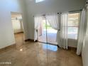 Light filled living room features tile flooring, access to patio, and views of the outdoor pool at 4034 E Anderson Dr, Phoenix, AZ 85032