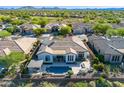 An aerial view showcases the backyard pool, pergola, and outdoor living space with lush landscaping and privacy at 40613 N Candlewyck Ln, Anthem, AZ 85086