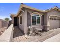 Inviting home exterior with a quaint seating area, desert landscaping, and a welcoming entryway at 4230 W Palace Station Rd, New River, AZ 85087