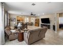 Spacious living room with tile flooring, a ceiling fan, fireplace, and comfortable furnishings at 4230 W Palace Station Rd, New River, AZ 85087