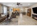 Open-concept living and dining area featuring tile floors, ceiling fan, and seamless kitchen access at 4230 W Palace Station Rd, New River, AZ 85087