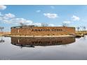 Community brick sign reflecting in pond under blue sky at 47154 W Coe St, Maricopa, AZ 85139