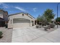 View of home with a two car garage, desert landscaping and sidewalk at 5418 W Carson Rd, Laveen, AZ 85339