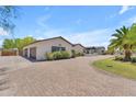 Paver driveway leads to a bright stucco home with an attached three car garage at 8213 E Sharon Dr, Scottsdale, AZ 85260