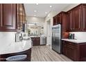 Modern kitchen features stainless steel appliances, dark wood cabinets, and stone countertops at 8848 E Conquistadores Dr, Scottsdale, AZ 85255