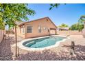 Backyard pool is surrounded by rock landscape and has a small grassy area beyond at 11318 W Monte Vista Rd, Avondale, AZ 85392