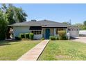 Inviting single-story home with a walkway, lush lawn, and a bright blue front door and white picket fence at 152 W 2Nd St, Mesa, AZ 85201