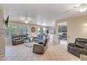 Spacious living room with tile flooring, ceiling fan, and a view of the kitchen at 15314 W Pantano Dr, Surprise, AZ 85374