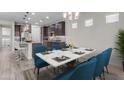 Bright dining room featuring a modern table, blue chairs, and natural light at 19606 W Grant St, Buckeye, AZ 85326