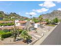 Charming home with desert landscaping, a red tile roof, and a mountainside in the background at 2016 E Orangewood Ave, Phoenix, AZ 85020