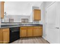 Well-lit kitchen showcasing wood cabinets, black appliances, and access to a side door at 2565 S Signal Butte Rd # 30, Mesa, AZ 85209