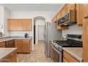 Modern kitchen boasts stainless steel appliances, ample counter space, and wooden cabinetry for storage at 29839 N Little Leaf Dr, San Tan Valley, AZ 85143