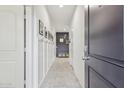 Inviting entryway featuring neutral tile, coat hooks, and a stylish accent wall with decorative elements at 36033 W Catalonia Dr, Maricopa, AZ 85138