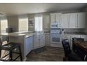 Well-lit kitchen with modern white cabinets, stainless steel appliances, and a bar seating area at 650 N Hawes Rd # 3312, Mesa, AZ 85207