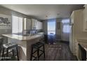 Open concept kitchen featuring white cabinetry, modern appliances, an eat-in table, and wood floors at 650 N Hawes Rd # 3312, Mesa, AZ 85207