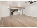 Spacious living area featuring light hardwood floors, a ceiling fan, and a modern chandelier at 715 S Saranac Ave, Mesa, AZ 85208