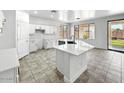 Open kitchen with granite countertops, an island, white cabinets, and tile flooring at 7243 W Sandra Ter, Peoria, AZ 85382