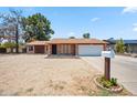Single-story brick home featuring a gravel front yard and a convenient two-car garage at 7430 E Ed Rice Ave, Mesa, AZ 85208