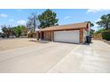 Well-maintained single-story brick home with a large driveway leading to a two-car garage at 7430 E Ed Rice Ave, Mesa, AZ 85208