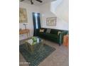Stylish living room featuring a green velvet sofa, modern decor, and ample natural light at 9205 W Williams St, Tolleson, AZ 85353