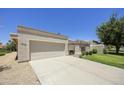 Beige single-story home featuring a large garage, low maintenance yard, and desert landscaping at 10538 E Gold Dust Cir, Scottsdale, AZ 85258