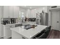 Modern kitchen island featuring stainless steel appliances, white cabinets, and quartz countertops at 1321 W 14Th St, Tempe, AZ 85281