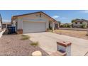 Home featuring a two-car garage and neutral paint, with a low brick wall and gravel in the front at 136 E San Angelo Ave, Gilbert, AZ 85234