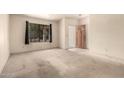Bright living room featuring a large window and neutral carpeting at 136 E San Angelo Ave, Gilbert, AZ 85234