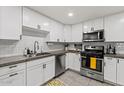 Well-maintained kitchen with stainless steel appliances, white cabinets, and grey countertops at 13614 N 38Th Pl, Phoenix, AZ 85032