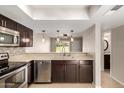 This modern kitchen offers dark cabinetry, stainless steel appliances, and a breakfast bar with pendant lights at 19601 N 7Th St # 1022, Phoenix, AZ 85024