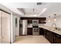 This kitchen features dark wood cabinets, stainless steel appliances, and light-colored countertops at 19601 N 7Th St # 1022, Phoenix, AZ 85024