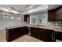 Well-appointed kitchen with dark wood cabinets, tiled floors, and stainless steel appliances at 2233 W Oraibi Dr, Phoenix, AZ 85027