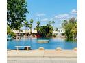 Beautiful lake view home featuring blue water, tall palm trees, and well-maintained landscaping at 244 N Rock St, Gilbert, AZ 85234