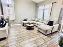Cozy living room featuring wood-look floors, a large sectional sofa, and natural light at 244 N Rock St, Gilbert, AZ 85234