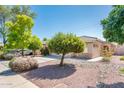 Lovely home with mature trees, rocks, and tidy landscaping creating curb appeal and charm at 2721 N 107Th Dr, Avondale, AZ 85392