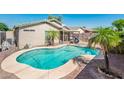 Backyard view with a private pool and palm trees, perfect for relaxation and outdoor enjoyment at 2721 N 107Th Dr, Avondale, AZ 85392