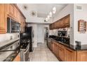 Well-lit kitchen featuring dark granite countertops, wood cabinetry, and stainless steel appliances at 3054 E Norwood St, Mesa, AZ 85213