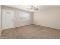 Inviting living room features neutral walls, carpet flooring, a ceiling fan, and ample natural light at 3118 W Aster Dr, Phoenix, AZ 85029