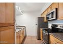 Traditional kitchen featuring wood cabinets, stainless steel appliances, and tile flooring at 3314 N 68Th St # 129, Scottsdale, AZ 85251