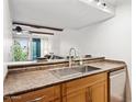 Kitchen featuring a serving bar, stainless steel sink and faucet, and built in dishwasher at 3314 N 68Th St # 129, Scottsdale, AZ 85251