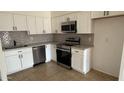 Bright kitchen features white cabinets, modern stainless steel appliances, and a stylish backsplash at 4217 W Medlock Dr, Phoenix, AZ 85019